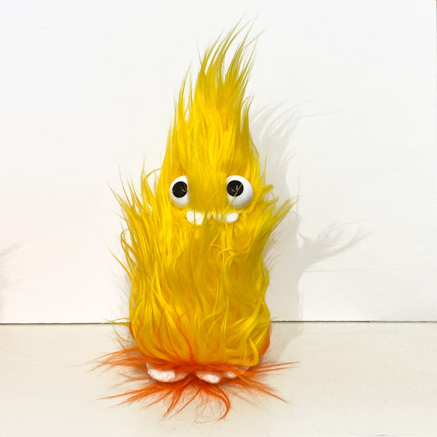 Very fluffy plush flame character with large plastic eyes, 2 buck teeth and flames under feet.