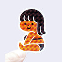 Sticker of a geometric-patterned character held by a hand on a light purple background