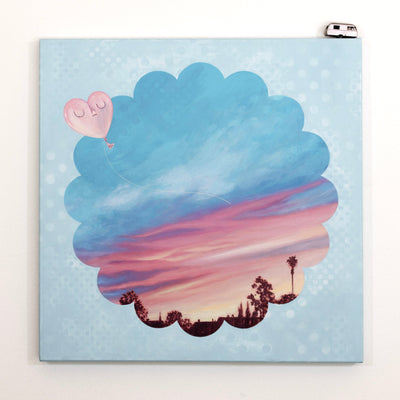 Painting on canvas of a sunset time with a silhouette of the tops of roofs and trees at the bottom. The scene is enclosed in a scalloped border with blue polkadots. 