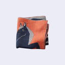Folded fabric with a horse design on an orange background
