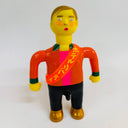Colorful toy figure with an orange shirt and sash on a white background