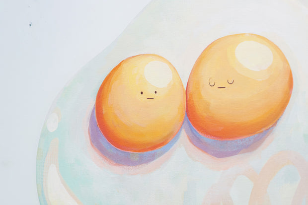 Die cut canvas of a pair of 2 eggs sharing a single egg white. The yolks are touching and have small faces. The egg white contains a subtle polka dot and scribble design.