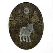 Paper cutting of many yellowish green pine trees, with a silhouette of a wolf painted onto the trees in a light blue. Above, using the same technique is a moon.