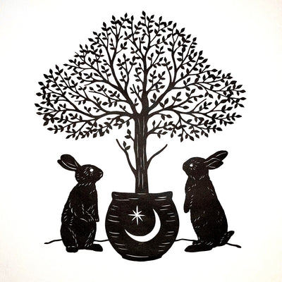 Paper cutting art from black paper, of 2 rabbits standing on their hind legs around a potted tree, with many individual leaves.