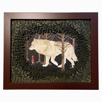 Assembled paper cutting diorama of a large white wolf, following a small girl in a red coat through a forest. They are framed by many cut leaves revealing the scene. Piece is in an open shadowbox style frame.
