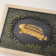 Paper cutting diorama of the Catbus from My Neighbor Totoro, flying though a starry night sky. The scene is framed with layers of cut leaves.