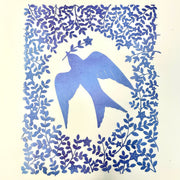 Purplish blue hand cut paper cut design of a bird carrying a single stemmed flower with a star shaped blossom. Around the bird is a pattern of leaves and flowers.