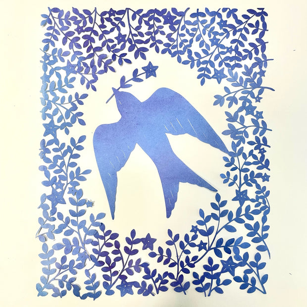 Purplish blue hand cut paper cut design of a bird carrying a single stemmed flower with a star shaped blossom. Around the bird is a pattern of leaves and flowers.