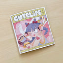 Booklet cover for "Cutelife Zine Issue 2" - featuring an illustration of a girl with purple braided hair and large anime style sparkling eyes, winking with her tongue out. She holds a greatsword over her shoulder, which is white aside from a floral pattern. She has a tattoo that reads "Cute Life" within a doily heart.