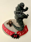 Sculpture of a tiny king kong, throwing around a giant godzilla by his tail on a base with Japanese writing.