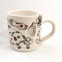 White ceramic mug with abstract designs in brown and orange.