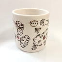 White ceramic mug with abstract designs in brown and orange.