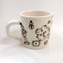 White ceramic mug with abstract designs in brown and orange.