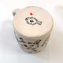 White ceramic mug with abstract designs in brown and orange.