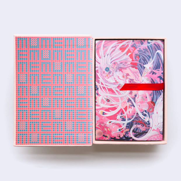 Hardcover box of postcards, open to reveal a grid style pattern within the box of "memu" written over and over. A red thread acts as a way to pull out the postcards.