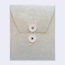 Beige textured envelope with decorative buttons on a white background
