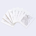 Set of postcard sized graphite artworks from James Jean, fanned out so a bit of each design can be seen slightly.