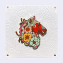 Enamel pin of a red horse with a mane made out of flowers.