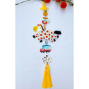 Decorative hanging with colorful horse clay sculpture, smaller charms including: a tangerine, cup of coffee, car and dog with a yellow tassel on a light blue background