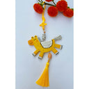 Tassel hanging of a flat clay sculpture of a yellow horse with beads on a yellow tassel.