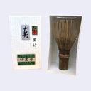 Bamboo whisk in packaging with brand labels on a white background