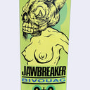 Skateboard deck with a graphic design featuring a rabbit skull as the head of a woman's topless body and text on a yellow background