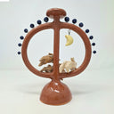 Ceramic sculpture with circular design featuring small rabbits jumping in the middle of the circule and a moon on a white background