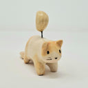 Ceramic cat figurine with a small yellow moon on its head, held up by a wire.