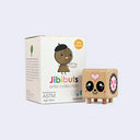 Small wooden square character figure standing on 4 peg-like legs with a cute cartoon smile. It stands next to its product packaging.