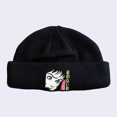 Black beanie with an embroidered graphic of a screaming girl, a close up of her face with yellow Japanese Kanji next to her.