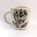 White mug with brown floral design on a white background