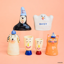 Set of colorful ceramic characters on a peach background