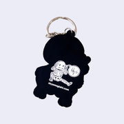 Black keychain with a white skeleton design and website text on a light gray background
