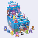 Collection of Care Bears figurines around a display box on a light gray background
