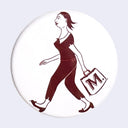 White circular button with a maroon graphic of a woman walking and carrying a bag that says "M." on it. She is seen from the side, mid stride.