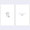 Open book with a black and white illustration on the left page and text on the right page.