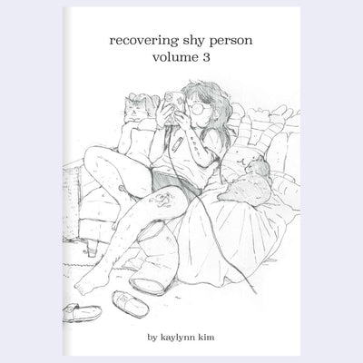 Book cover of 'recovering shy person volume 3' by kaylynn kim with an illustration of a person sitting on a couch looking at their phone.