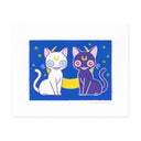 An artwork featuring two stylized cats, one white with blue eyes and a yellow crescent moon on the forehead, and one dark purple with red eyes and a yellow crescent moon on the forehead, seated against a blue background with small yellow stars. 