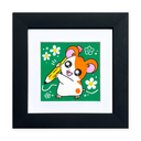 A framed artwork featuring a cute cartoon hamster holding a yellow pencil on a green background, surrounded by white flowers. The artwork is matted with a white border and enclosed in a thick black square frame, shown against a plain white background.