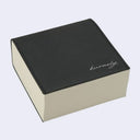 Thick memo pad with a black pleather cover with cursive writing on it reading "kurasky"