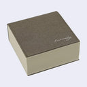 Thick memo pad with a greyish-brown pleather cover with cursive writing on it reading "kurasky"