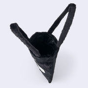 Fluffy black faux fur tote bag with Kuromi's cute, frowning face on the front with an embroidered skull over her forehead. It has 3D fluffy ears, shaped like Kuromi's. Seen from overhead.