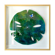 Painting on cut out paper of a round blue and green marble patterned lily pad and thin white lines. A small blue and white butterfly sits atop the pad. Piece is in a thin, light grain wooden frame.