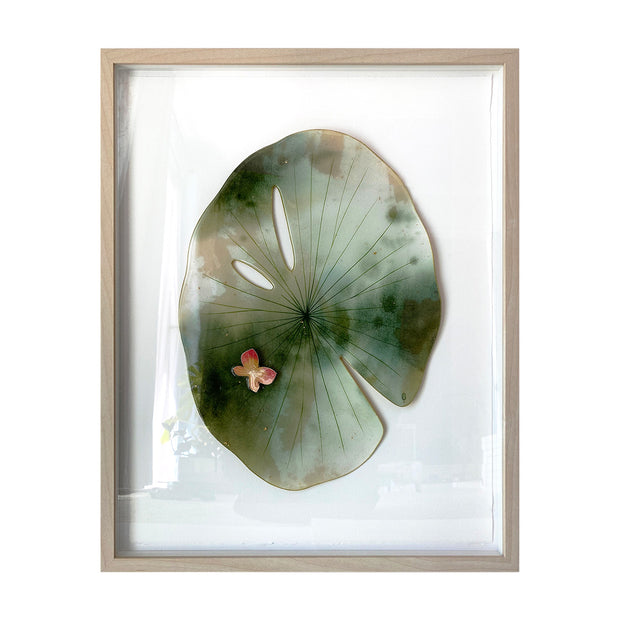 Painted cut out lily pad leaf, greyish green with subtle marbling pattern and thin black stripes. A small red and yellow butterfly rests atop the leaf. Piece is framed in thin, light grain wood frame.