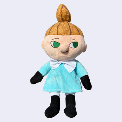 Plush doll of Little My, a character with a subtle smiling expression, looking off to the side. She has a tall ponytail and light blue dress.