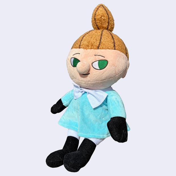 Plush doll of Little My, a character with a subtle smiling expression, looking off to the side. She has a tall ponytail and light blue dress.