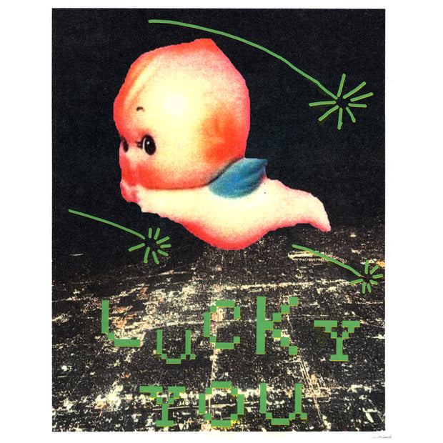 Screenprint of a lit up city at night, seen from overhead and far away as if in a plane. A large Kewpie baby flies overhead, with green shooting stars and pixilated text that reads "Lucky You."