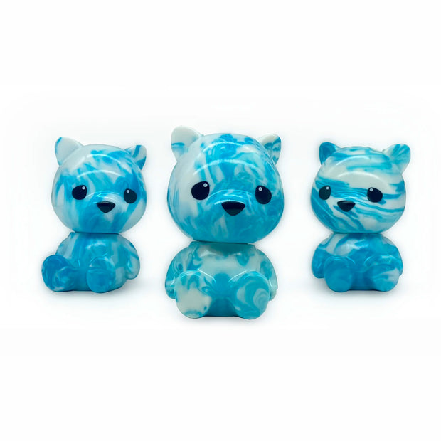 3 small sofubi bears with large heads, blue with white marbling. They sit on the floor with large eyes and a nose and no other defining facial features.