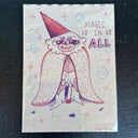 A a whimsical hand-drawn wizard character with a pointed red hat, white fluffy hair, and a patterned cape, surrounded by stars and swirls. The text reads 'MAGIC IS IN US ALL' in purple and pink lettering.