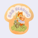 Die cut sticker of a cat reading a book next to a tiny mouse, also reading a book, with 'BRB Reading' text overhead on an orange background.